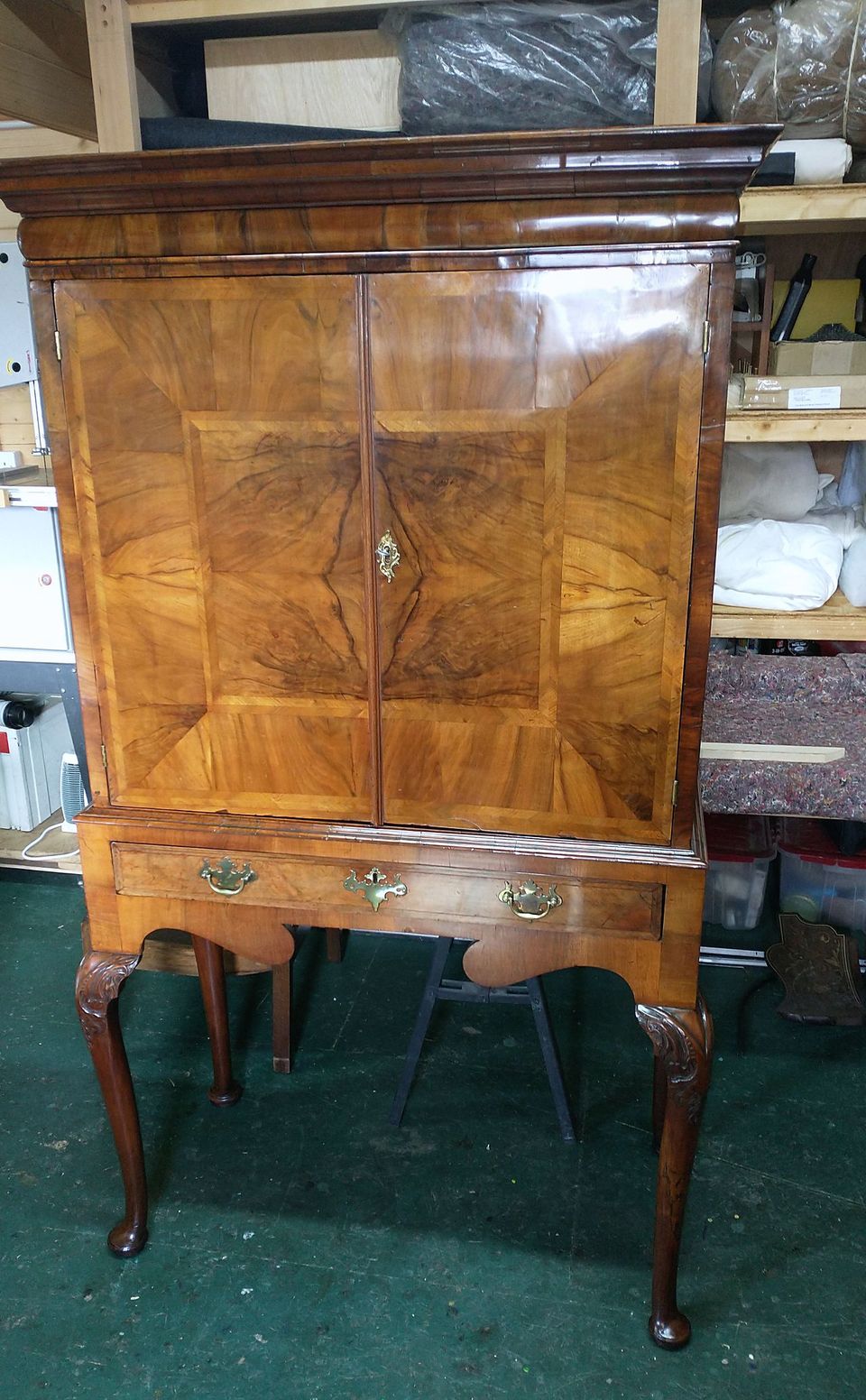 Cabinet on stand with figured veneer doors, crossbanding, brass handles and cabriole legs, after polishing
