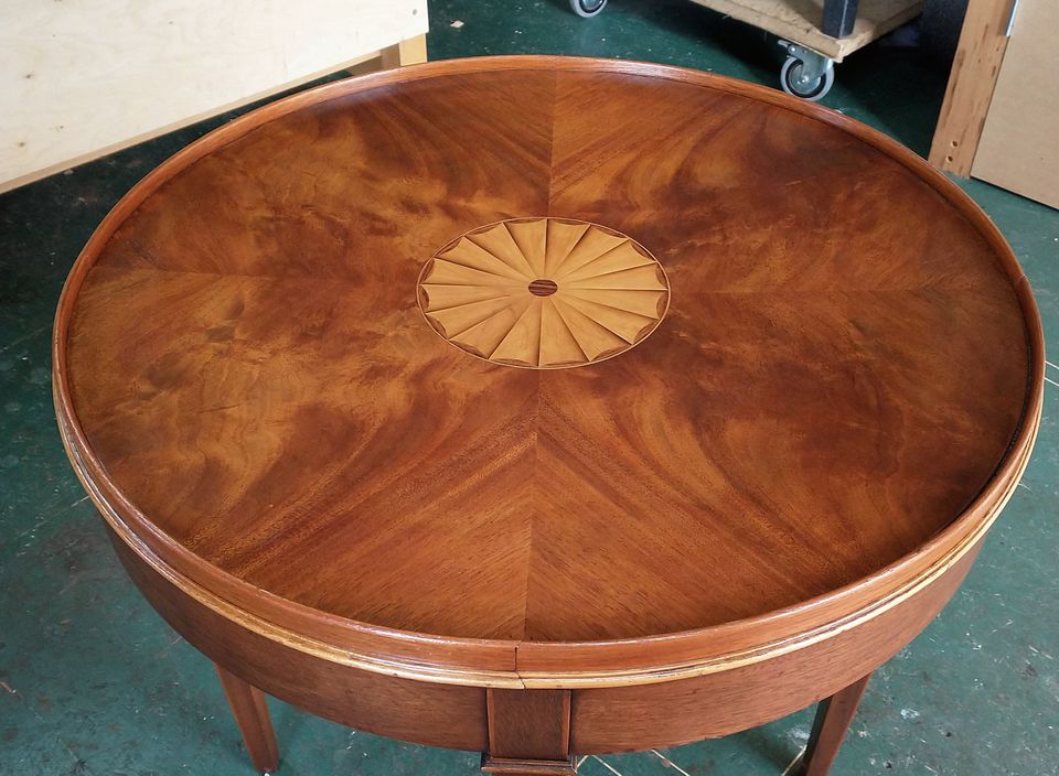 Round table with a sunburst veneer top and inlaid fan centre, French polished